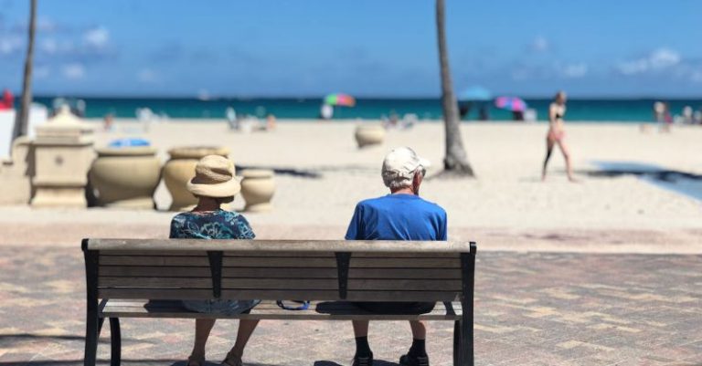 Retirement Beach - Man and Woman Sitting on Brown Wooden Bench