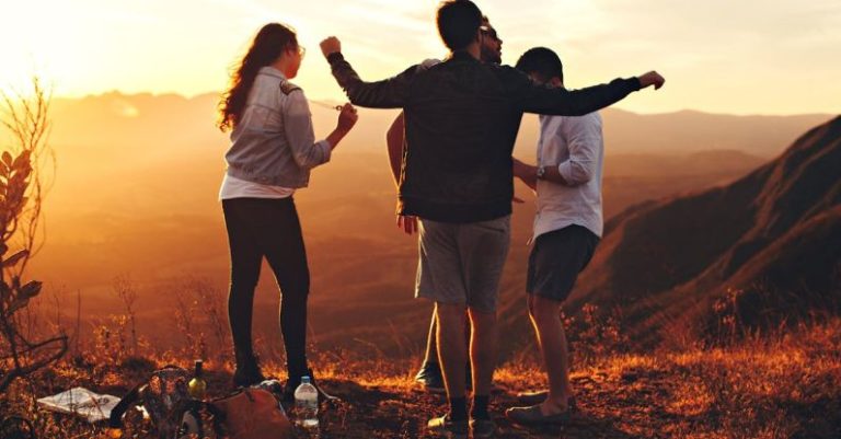 Millennials Group - Four Person Standing at Top of Grassy Mountain