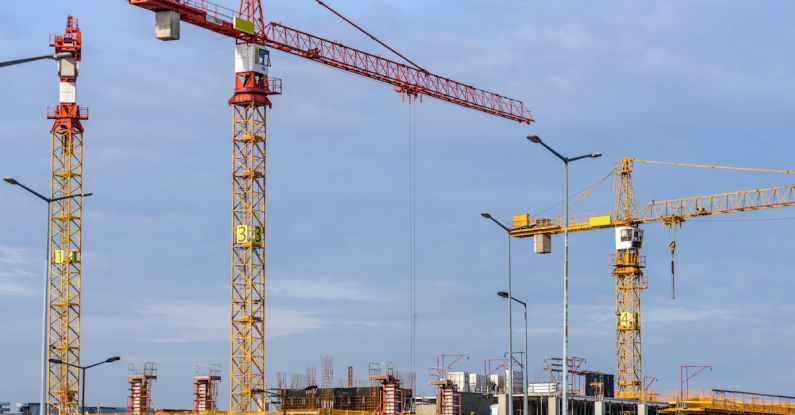 Construction Technology - Three Yellow and Red Tower Cranes Under Clear Blue Sky